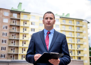 performance facility management team member building manager in front of residential apartement block