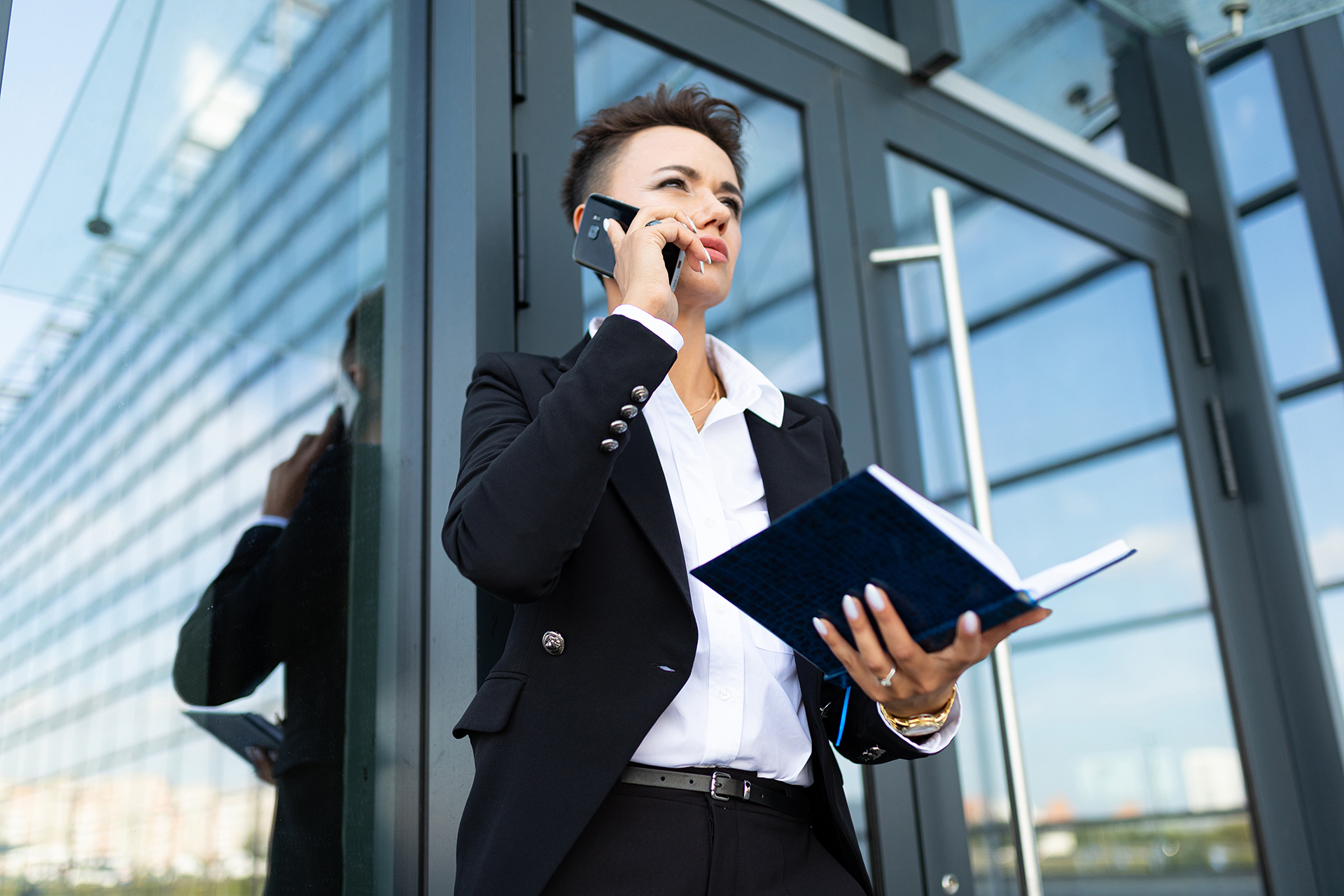 Management by crisis - Building Manager executive out if her building on the phone to the contractor as she manages the crisis of a major fault in Melbourne CBD