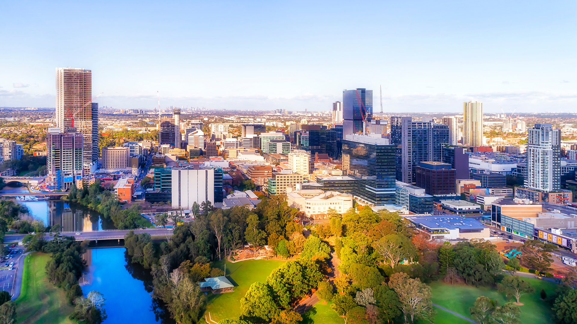 An executive building manager with city commercial office towers and commercial property in shadows behind him