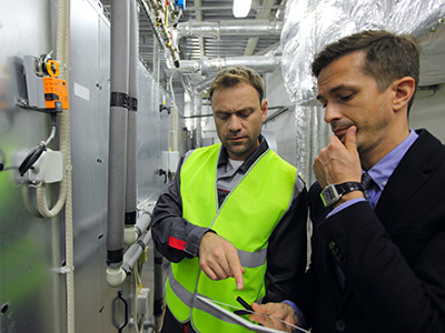 Building manager talking with senior BMS Technican