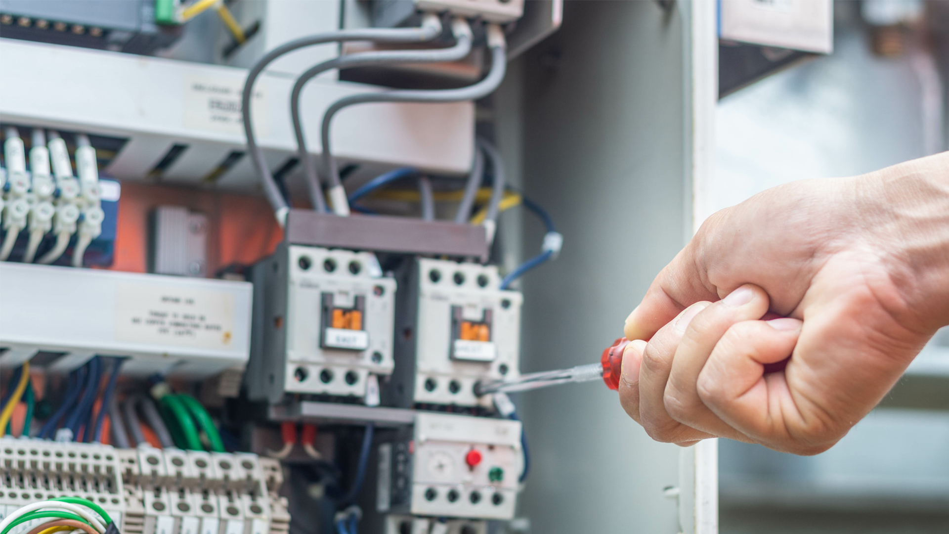 Contractor and Maintenance Management - Technician working in a Mechanical Services Motor Control Switchboard