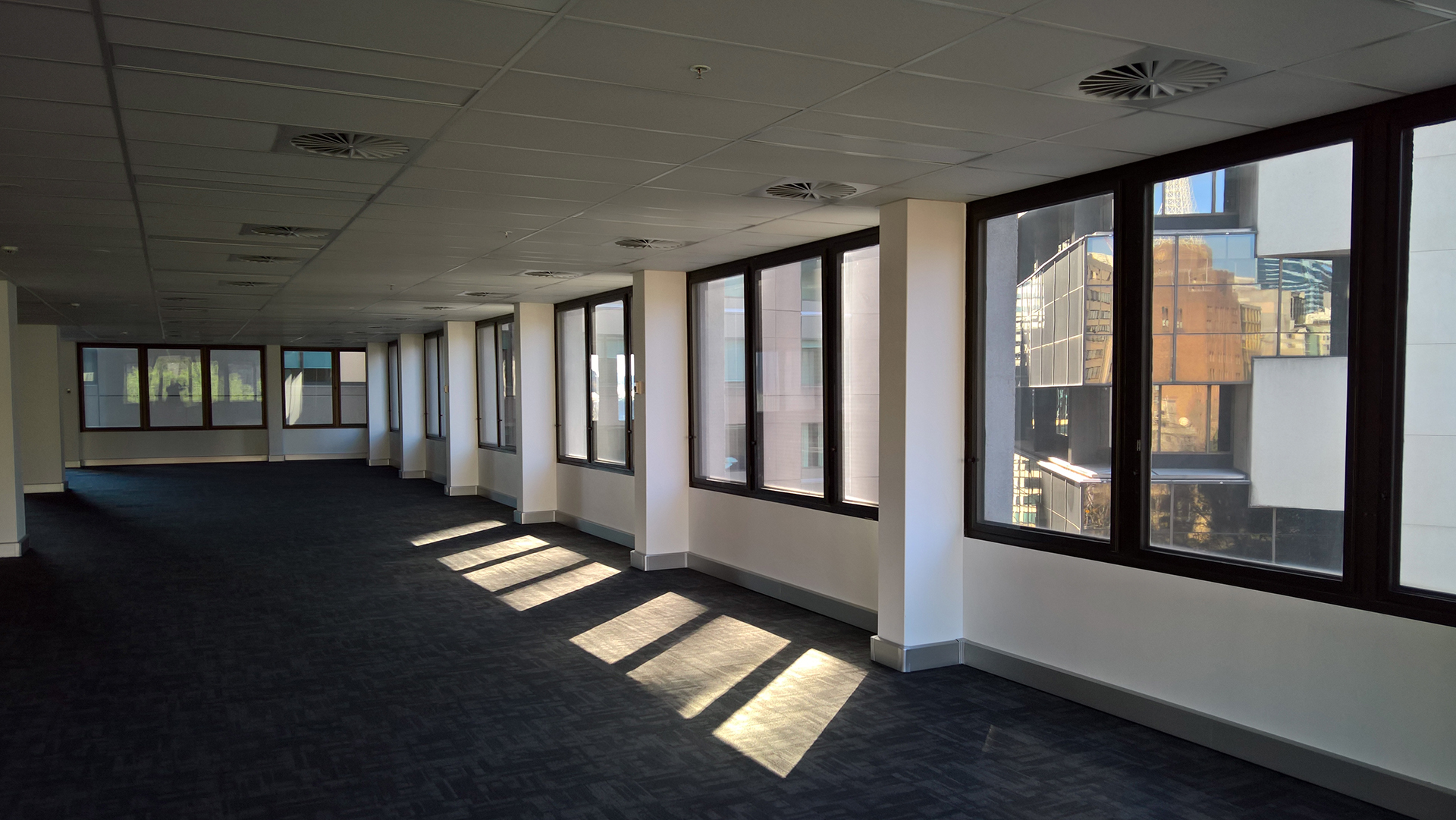 An unsupervised building in the Sydney CBD showing us an unoccupied floor facing south with the contents removed as the floor as up for a new Lease
