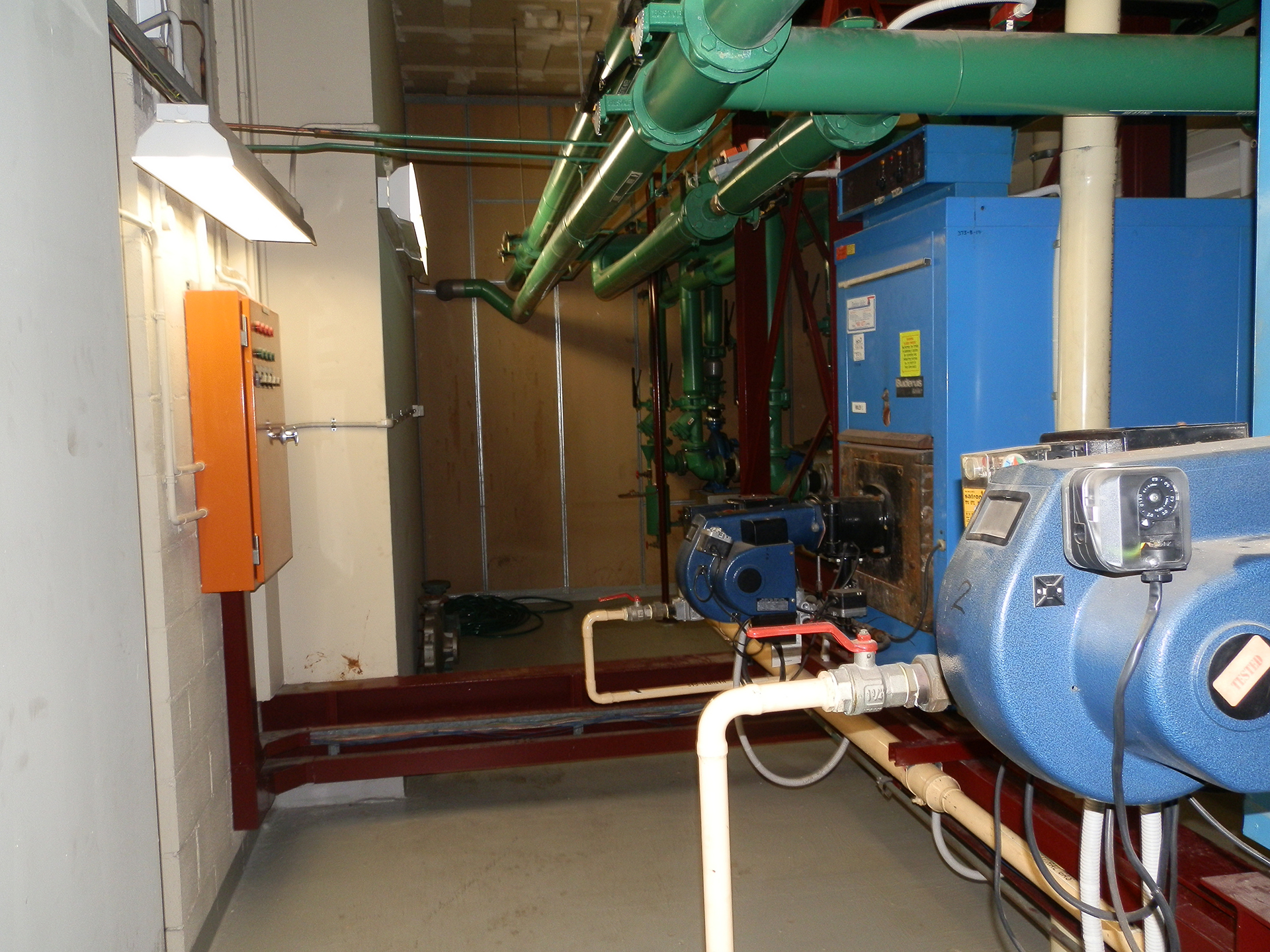 A large commercial three-stage reciprocating chiller installed within a mechanical plant room, servicing a commercial building HVAC system in Australia. The chiller features multiple reciprocating compressors, chilled water pipework, isolation valves, pressure gauges, control panels, and industrial mechanical services infrastructure designed for reliable cooling performance in medium to large commercial facilities. The image highlights critical fixed assets commonly found in commercial office buildings, hospitals, shopping centres, and industrial facilities across Sydney, Melbourne, and Canberra. The scene represents commercial HVAC engineering, preventative maintenance, energy management, plant reliability, and lifecycle management of major mechanical services equipment.
