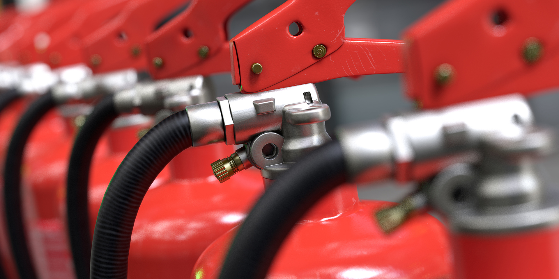 Close-up view of a row of commercial fire extinguishers aligned in sequence, highlighting fire safety equipment and compliance requirements for buildings in Sydney, Melbourne and Canberra.