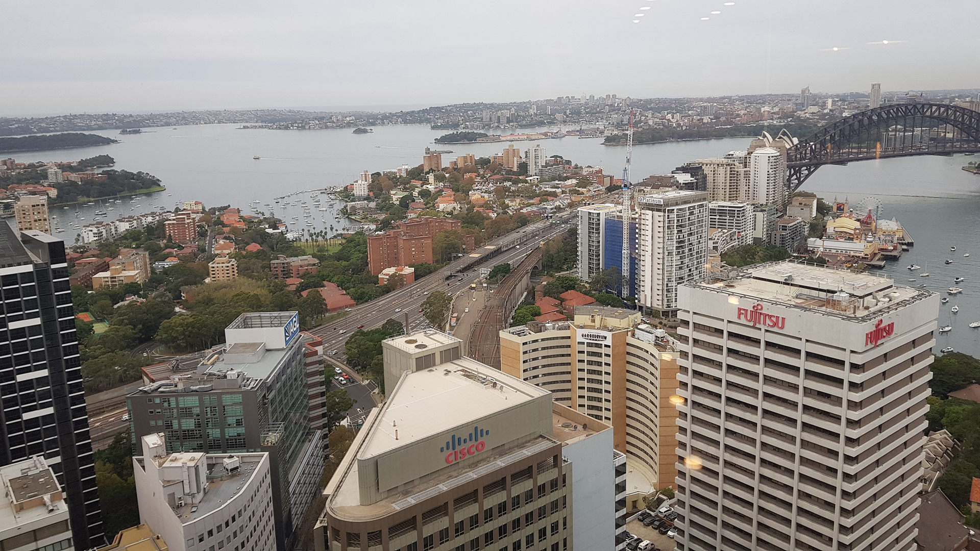 View across Sydney CBD commercial office buildings towards Sydney Harbour Bridge, illustrating the commercial property market supported by Performance Facility Management.