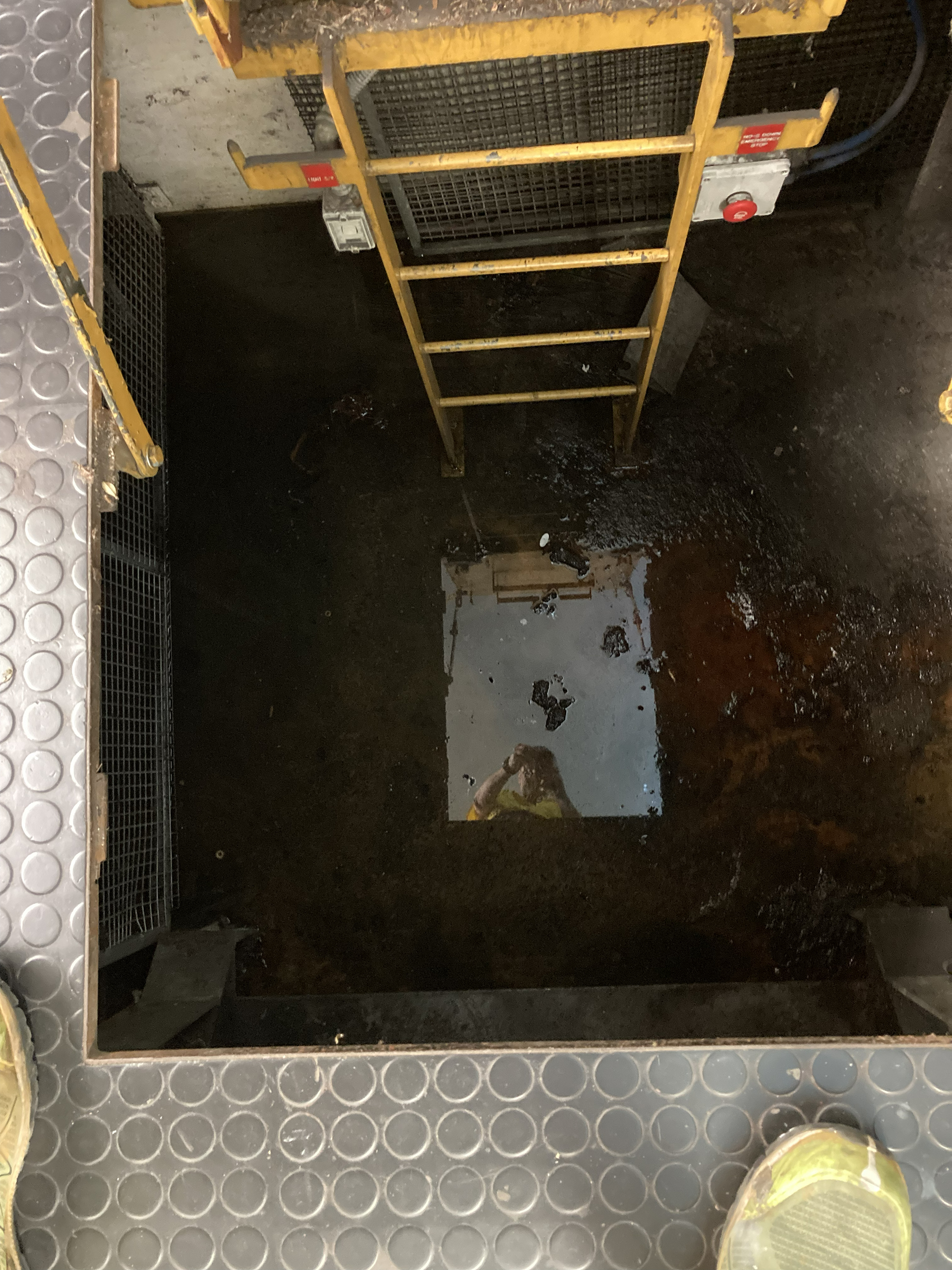 Flooded travelator pit beneath the Domain Travelator in Sydney requiring emergency reactive mechanical maintenance and fault investigation.