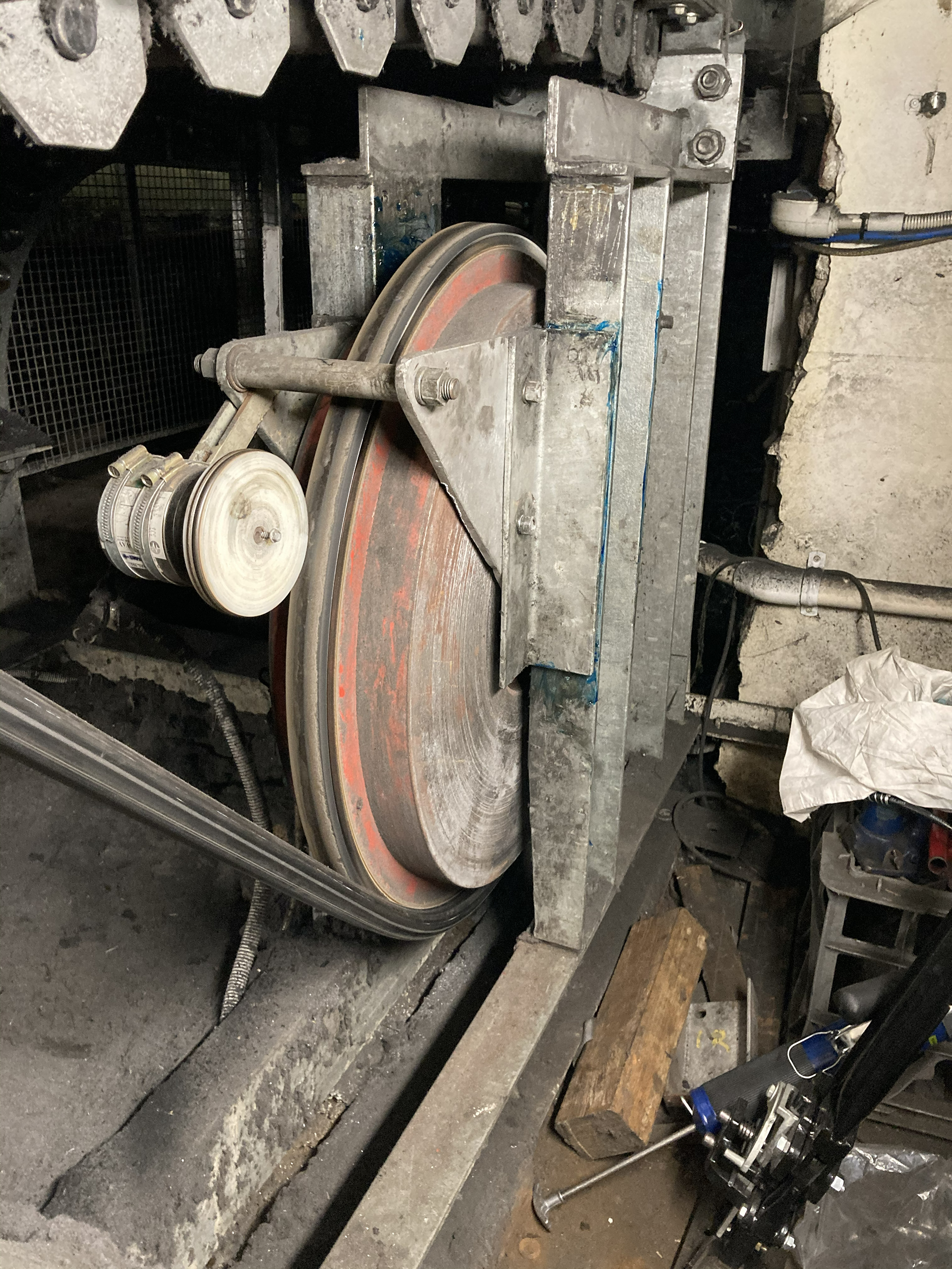 Mechanical drive pulley and roller assembly beneath the Domain Travelator in Sydney undergoing reactive mechanical maintenance and repair by commercial building maintenance technicians.